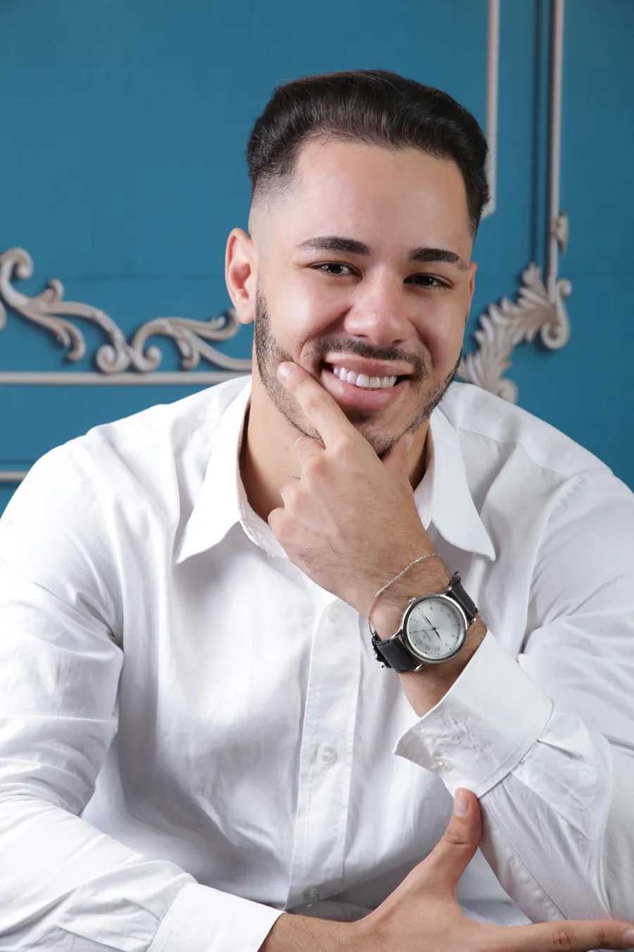 Retrato do advogado Lucas Tupiná sorrindo, de camisa branca